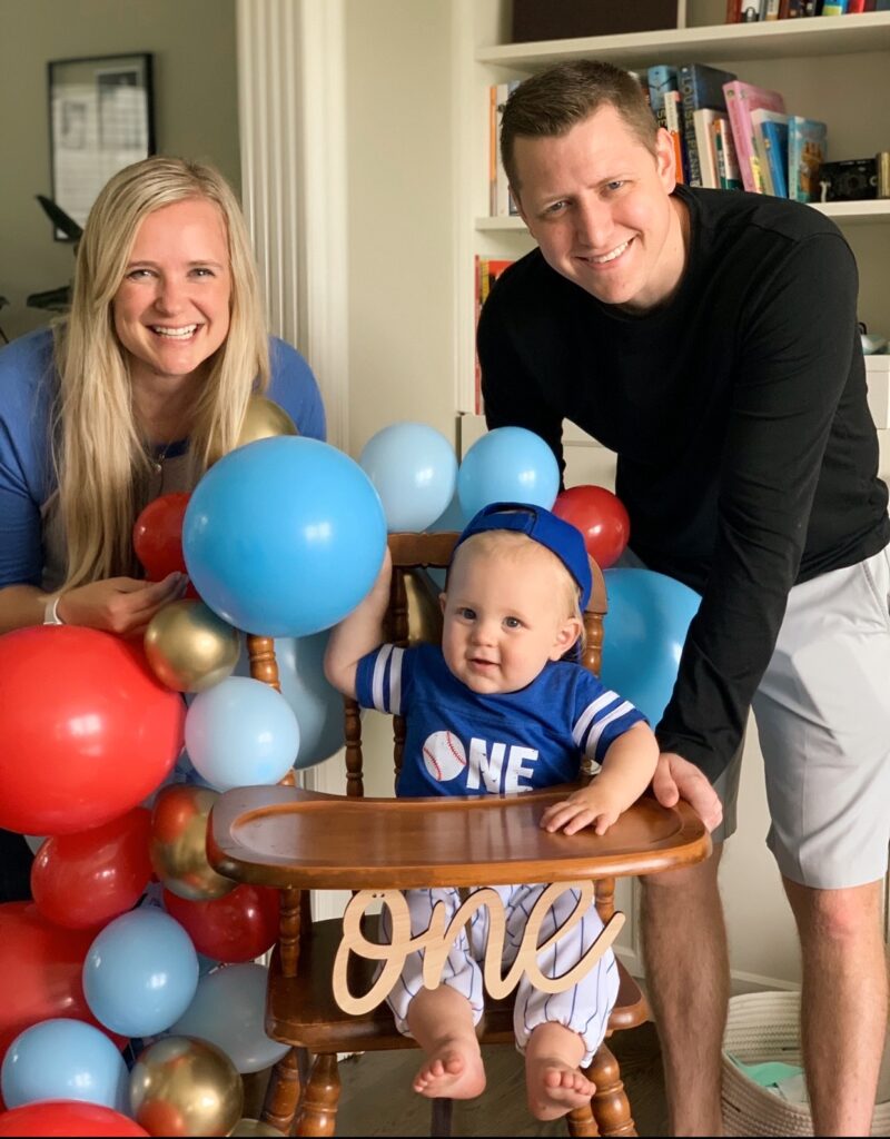 toddler with parents in a highchair for his birthday