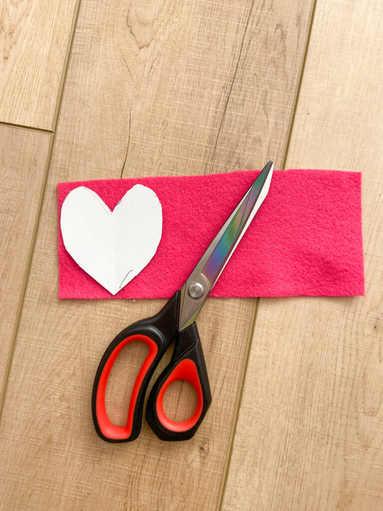 Scissors cutting a heart shape out of felt. 