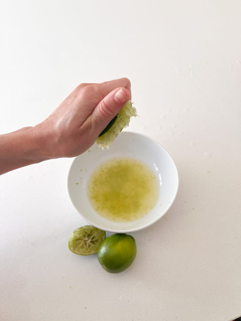juicing limes into a bowl