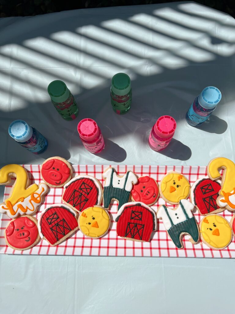 Farm-themed cookies and bubbles sitting on a table. 