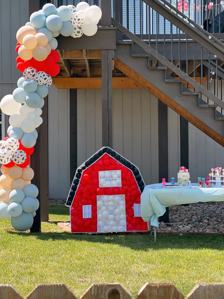 backyard with balloon arch and farm-themed decor. 
