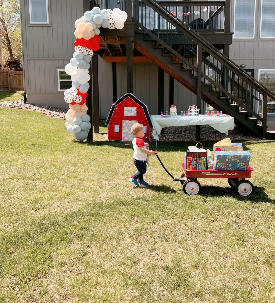 Little boy in backyard with farm themed birthday decorations.