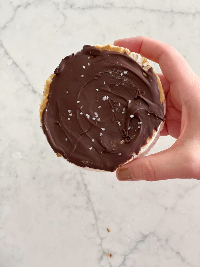 rice cake topped with peanut butter, chocolate and sea salt. 