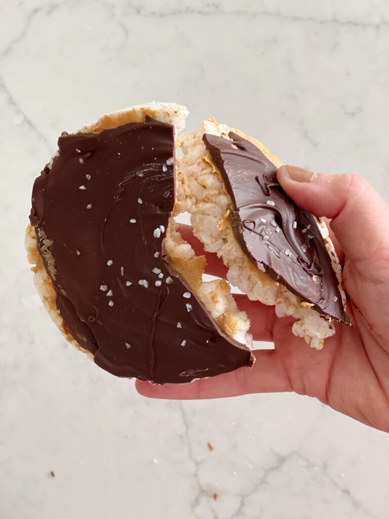 rice cake with peanut butter and chocolate broken in half. 