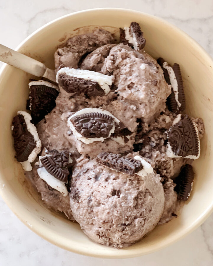 oreo ice cream in a yellow bowl with spoon.