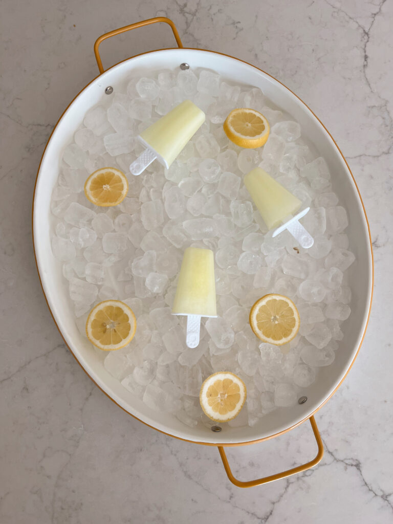 lemons on a tray with ice and lemon slices. 