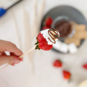 toasted strawberry on skewer and topped with chocolate.