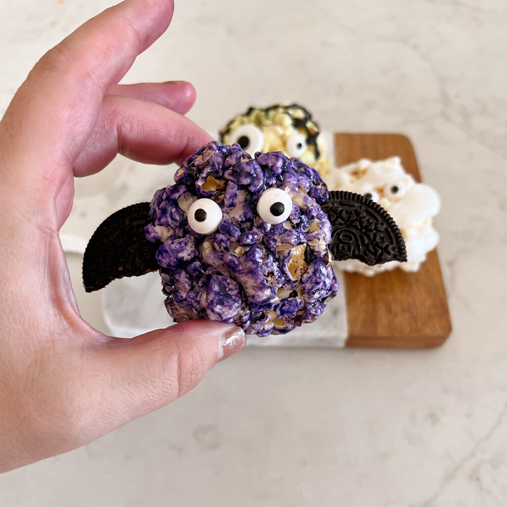 popcorn ball in shape of a bat with oreo pieces as wings.