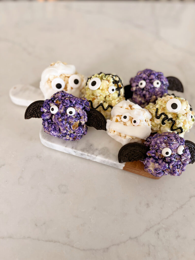 Popcorn balls on a tray decorated for Halloween.