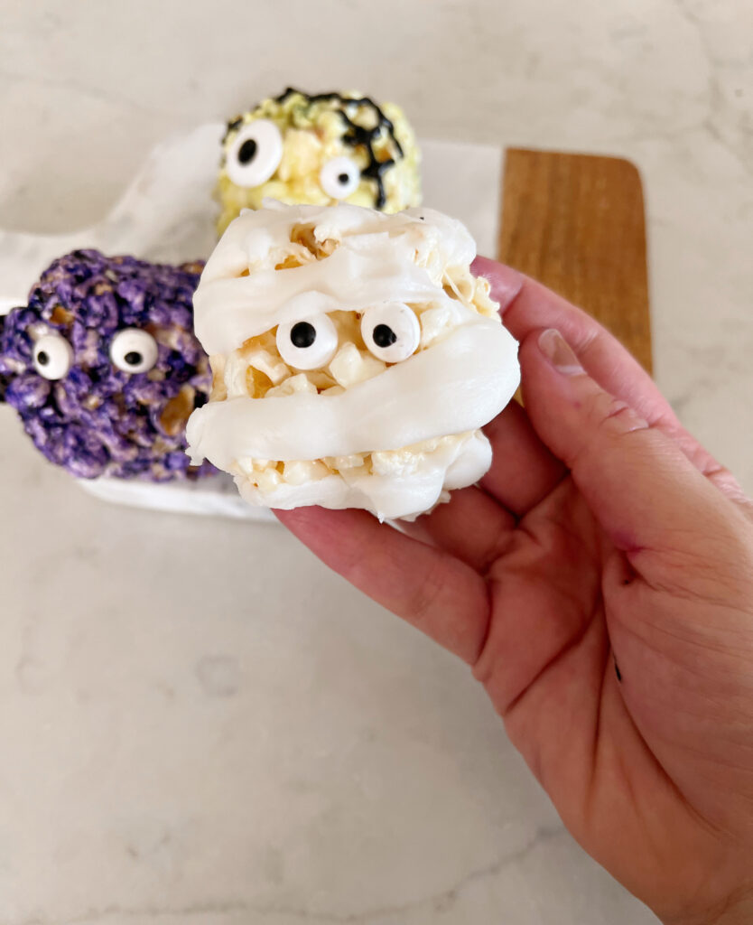 popcorn ball with googley eyes and white icing to look like a mummy. 