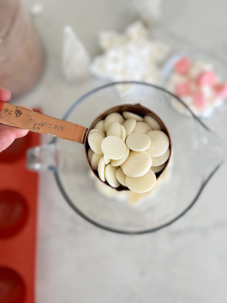 White chocolate melting wafers in measuring cup.