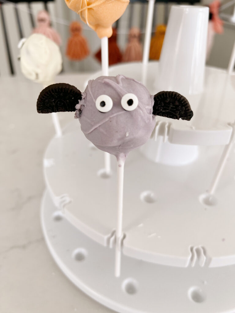 Purple cake pop with googley eyes and oreo pieces as wings to look like a bat. 