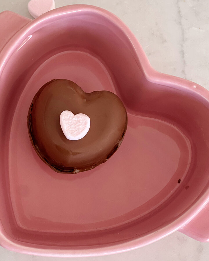heart-shaped hot cooca bomb in a heart-shaped baking dish.