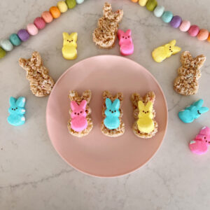 peeps marshmallows and rice krispie treats on a pink plate.