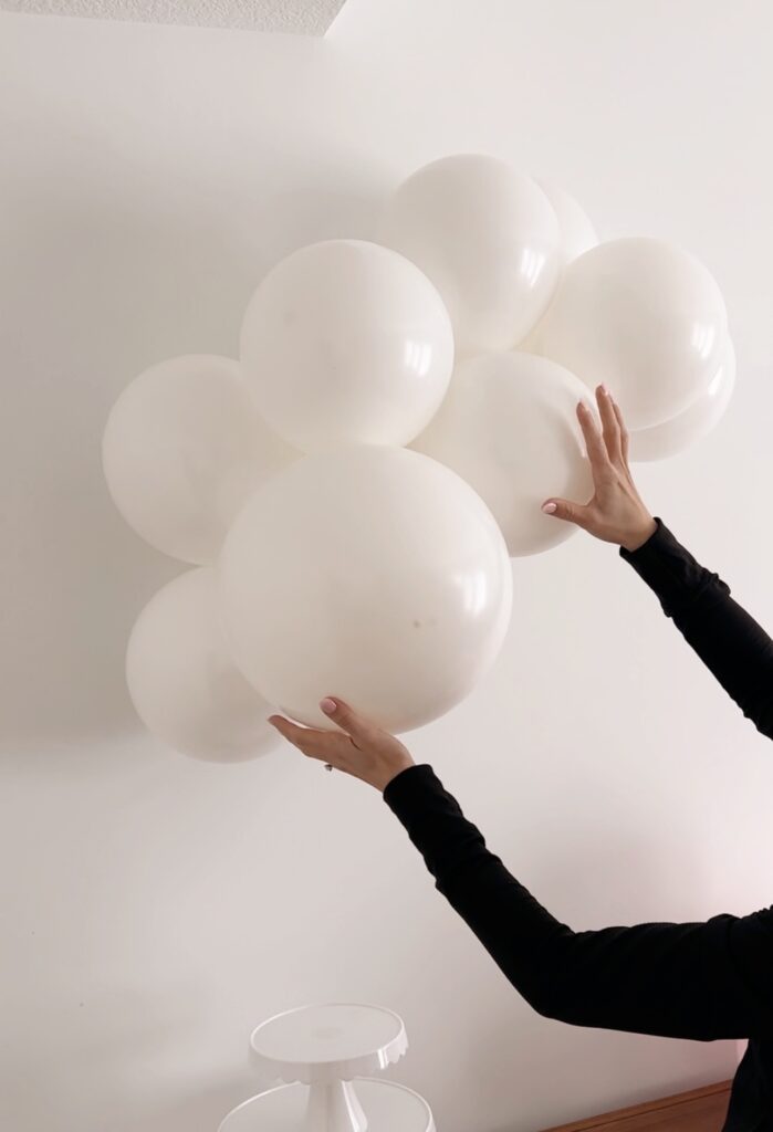 white balloons being placed on a wall. 