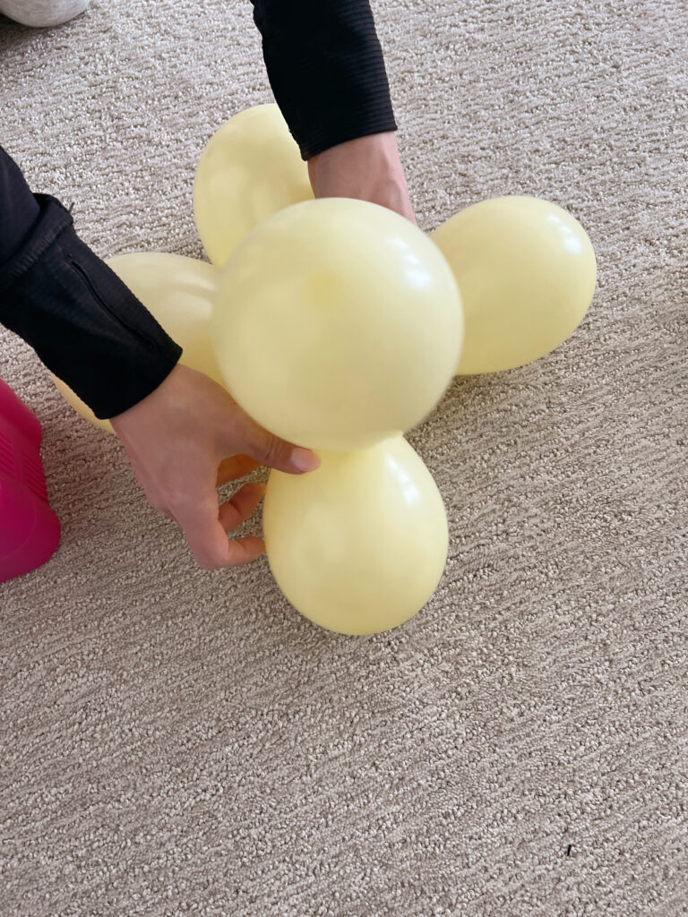 Yellow balloons being twisted together and secured. 