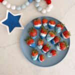 strawberries dipped in white chocolate with blue swirls or sprinkles added.