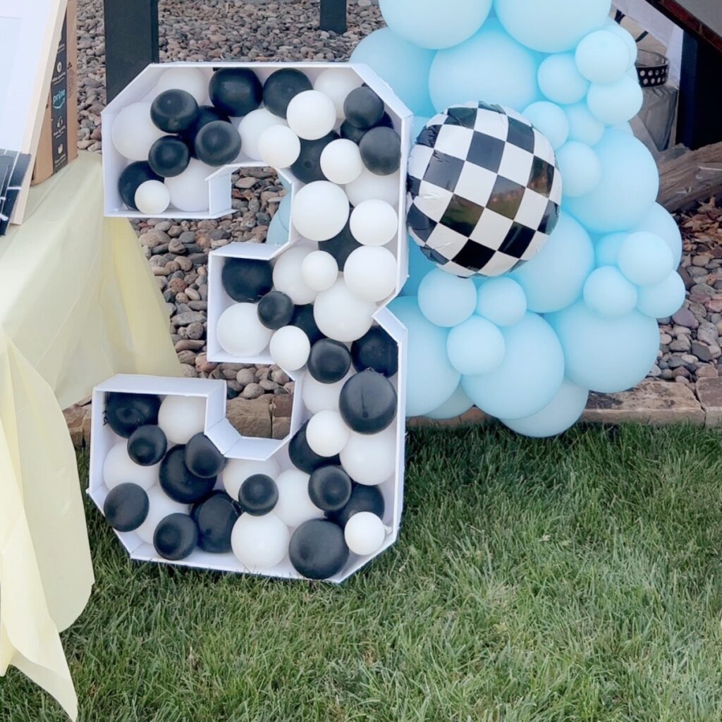 number 3 balloon mosaic made with foam board and filled with white and black balloons.