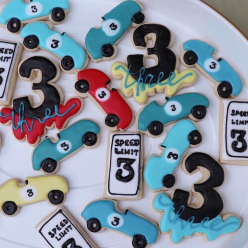 Sugar cookies decorated with royal icing in race car shapes.