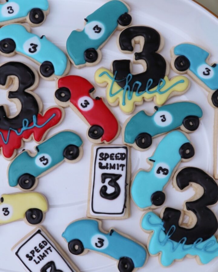 Sugar cookies decorated with royal icing in race car shapes.