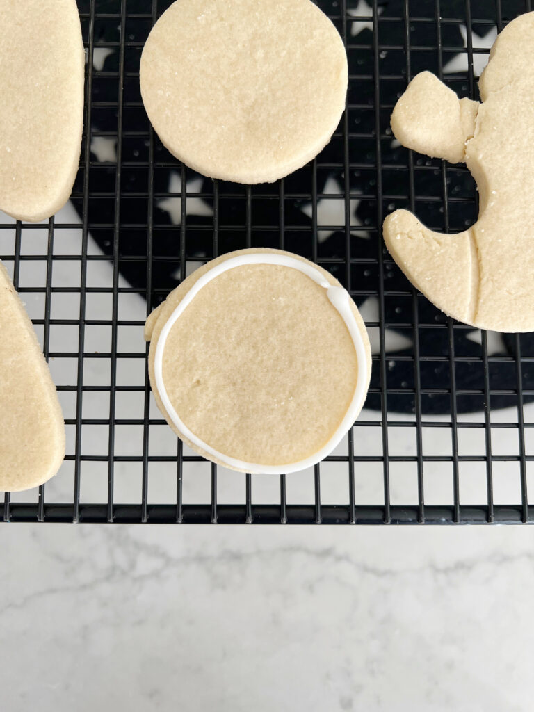 Sugar cookie in the shape of a circle with a white outline for decorating. 