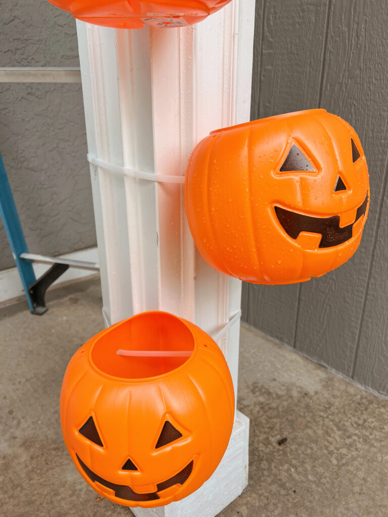 Plastic Pumpkins being added to column of porch. 