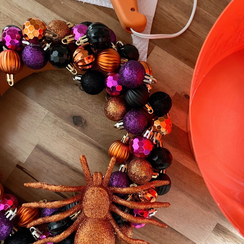 Halloween wreath made with ornaments and decorative spider.