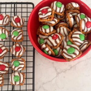white chocolate and m&m pressed onto a grid shaped pretzel in a bowl for serving.
